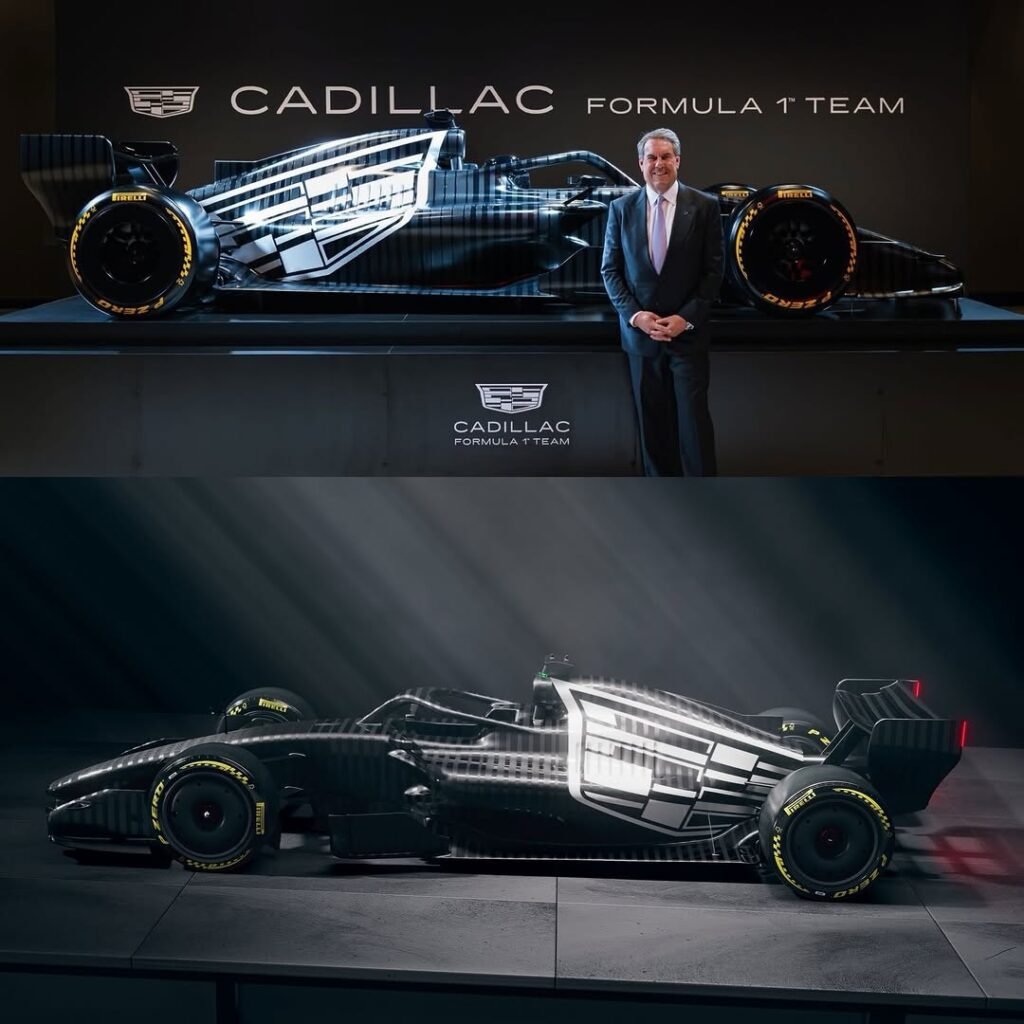 Monoplaza Cadillac F1 negro con patrón geométrico blanco en perfil lateral, sobre escenario con logo; ejecutivo posando a un lado, iluminación de estudio.