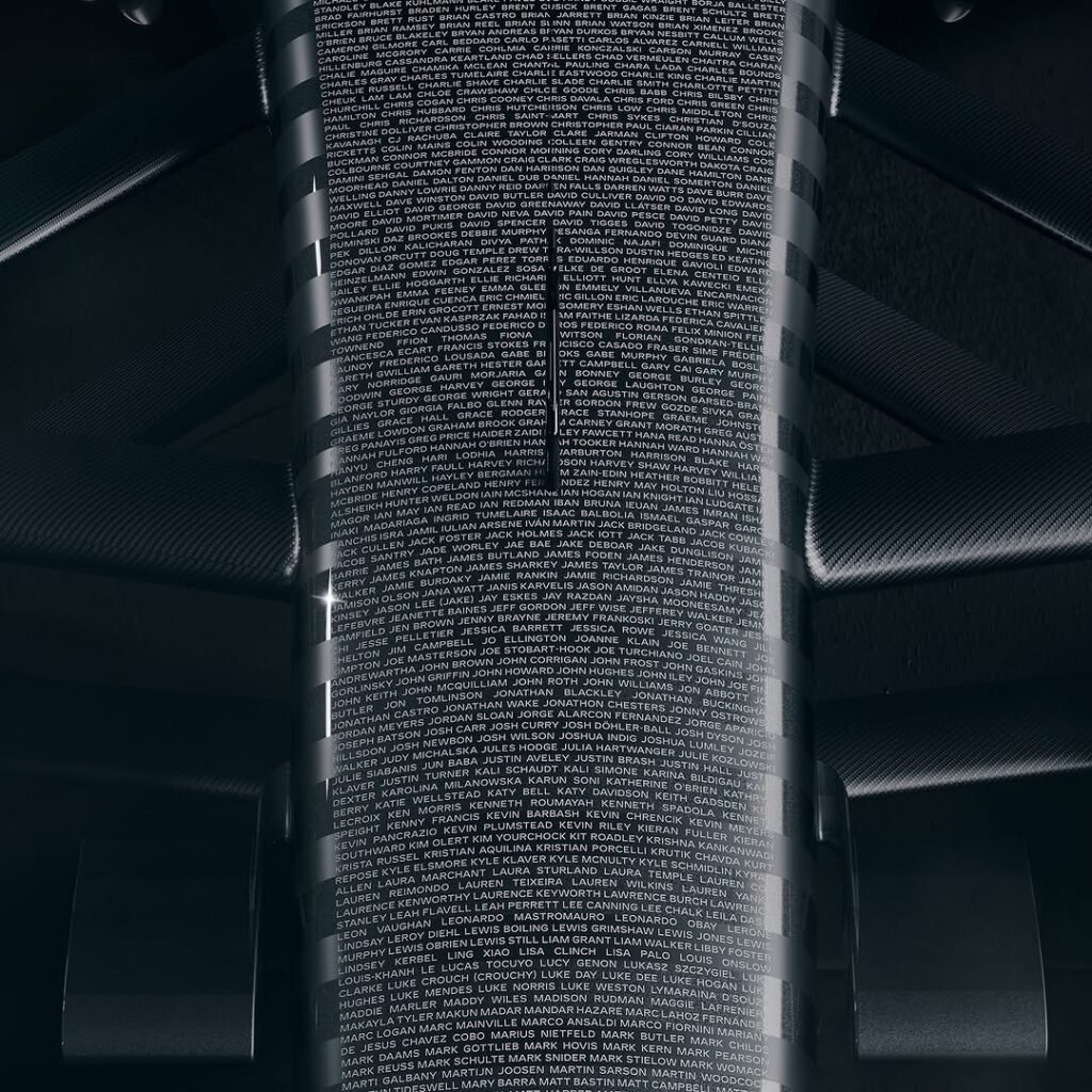 Acercamientos al morro y a una sección trasera del Cadillac F1 con miles de nombres impresos en blanco sobre fondo negro; textura fina sobre fibra de carbono.